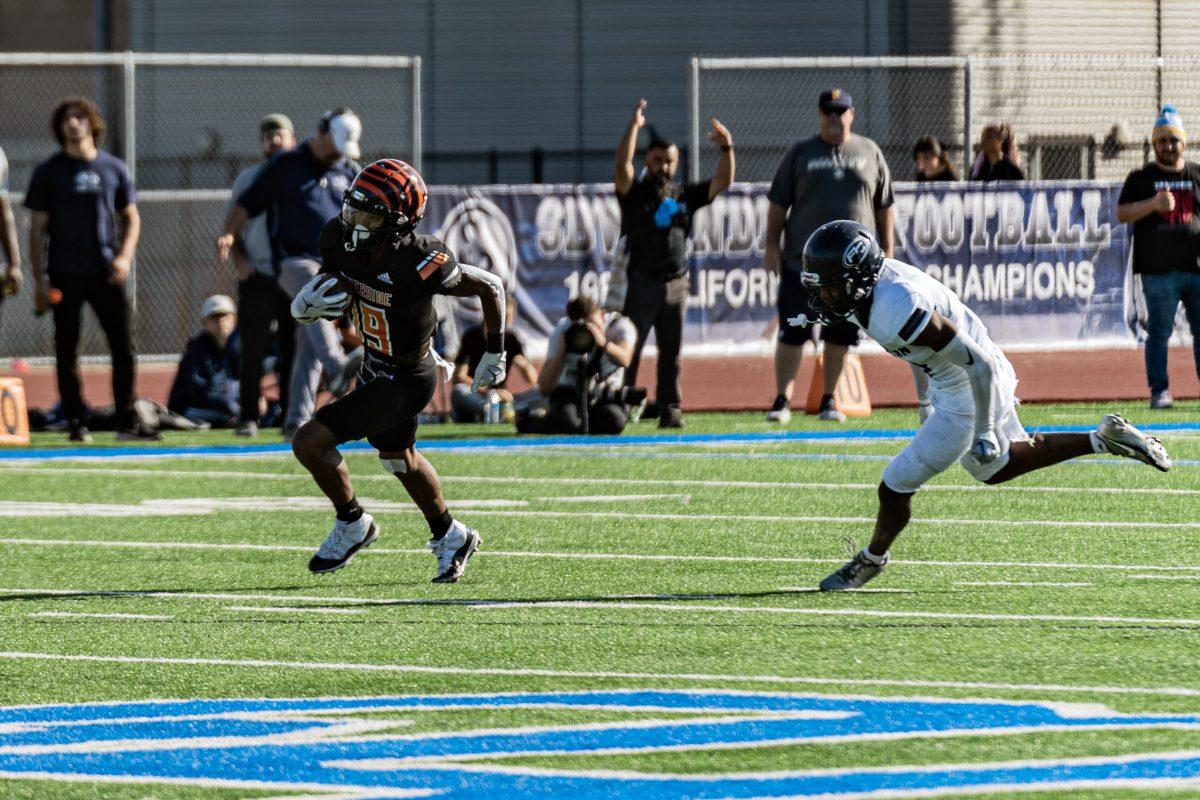 Tiger's Alfred Jordan easily avoids the Fullerton College Hornet's defensive line and runs the completed pass for a 74-yard touchdown during the SCFA Championship game at San Bernardino Valley College on Dec 3.

Tigers defeated the Hornets 31-17 and will move on to the Chapionship game against San Mateo College.