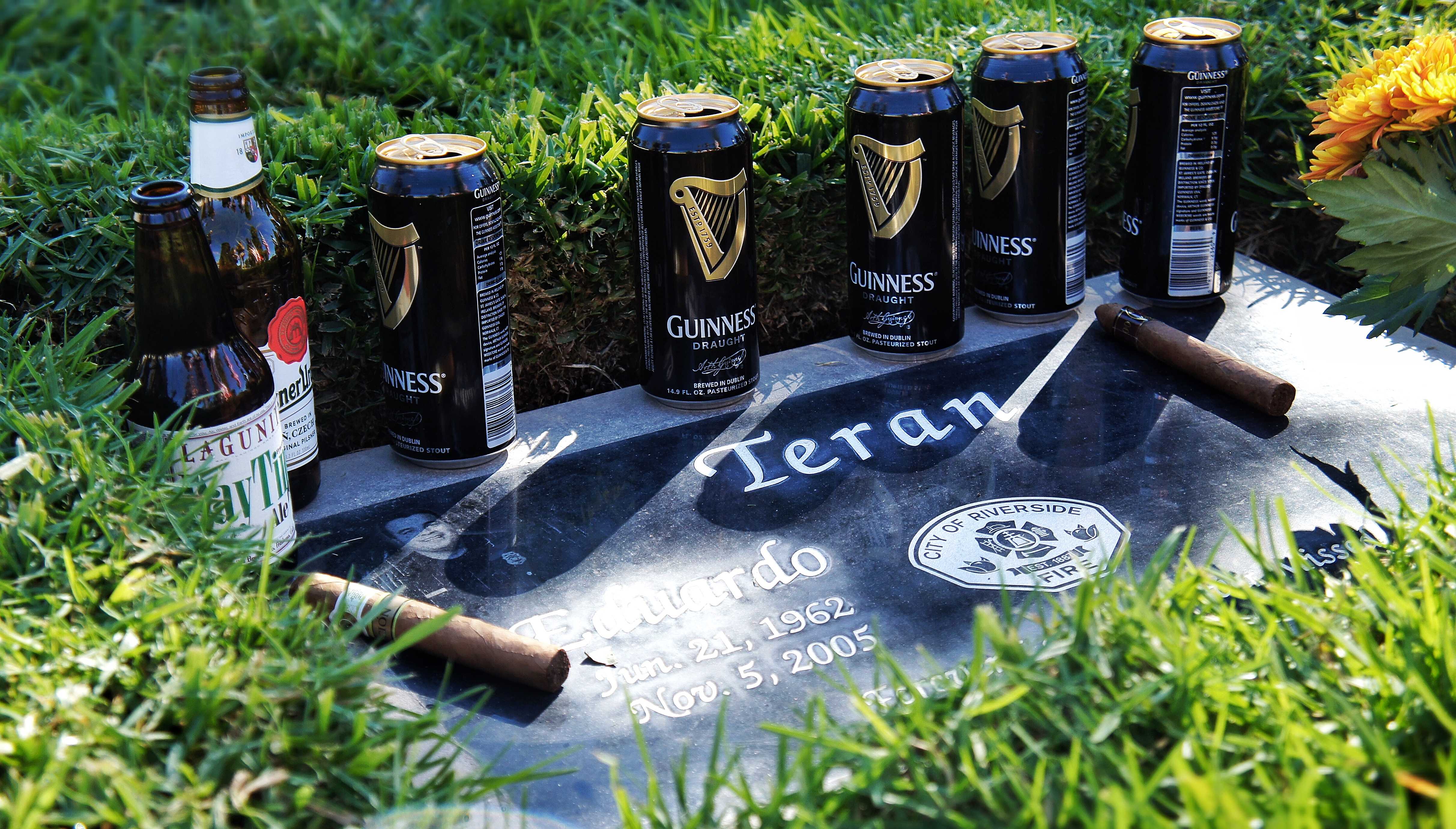 Firefighters grace Teran’s head stone with cigars and beers at his burial site in Riverside.  