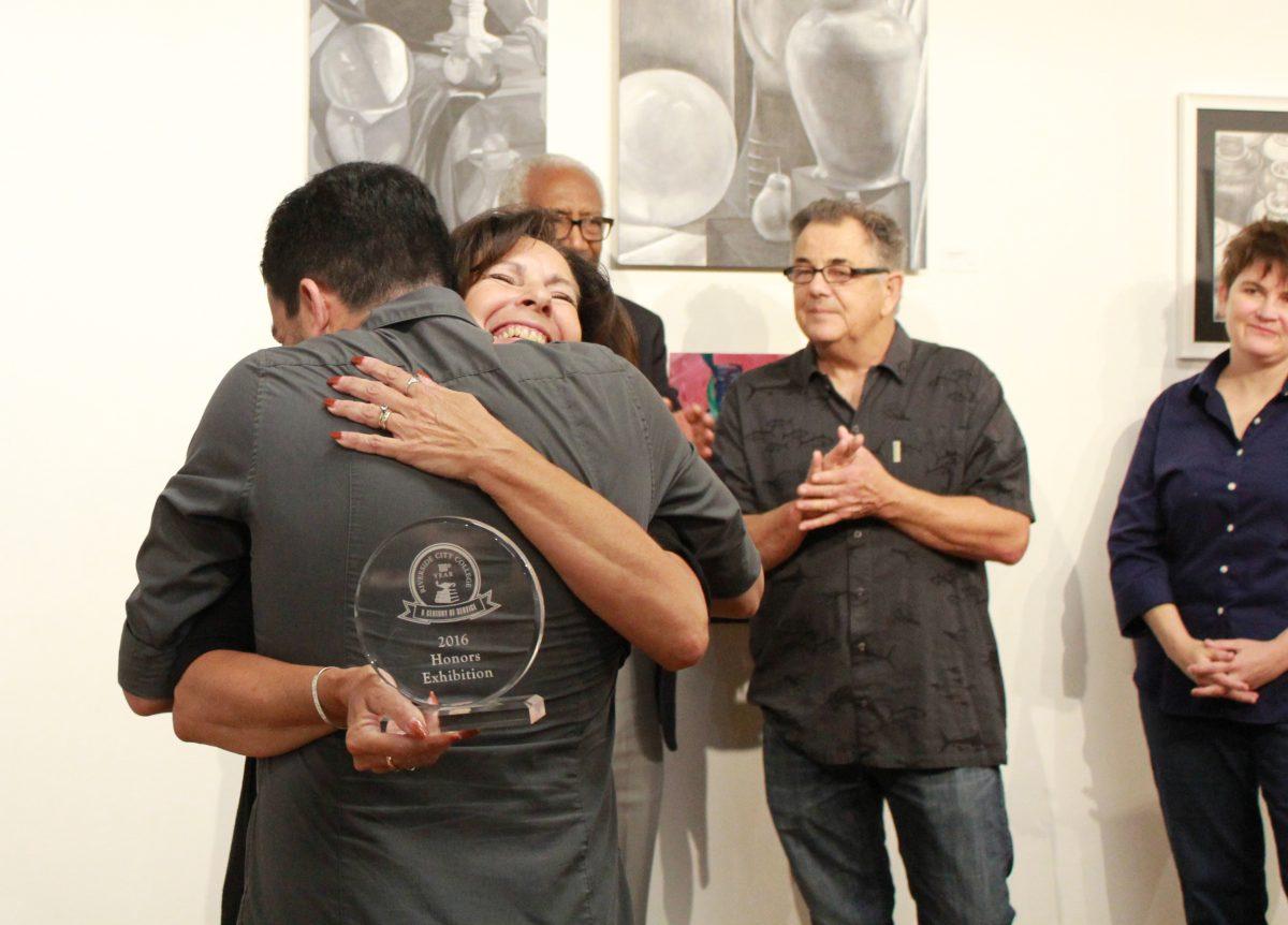 Carla Conti, photography instructor, hugs Hugo Fernando while presenting a Student Honors Award at the Student Honors Exhibition 2016 reception and award ceremony May 5.