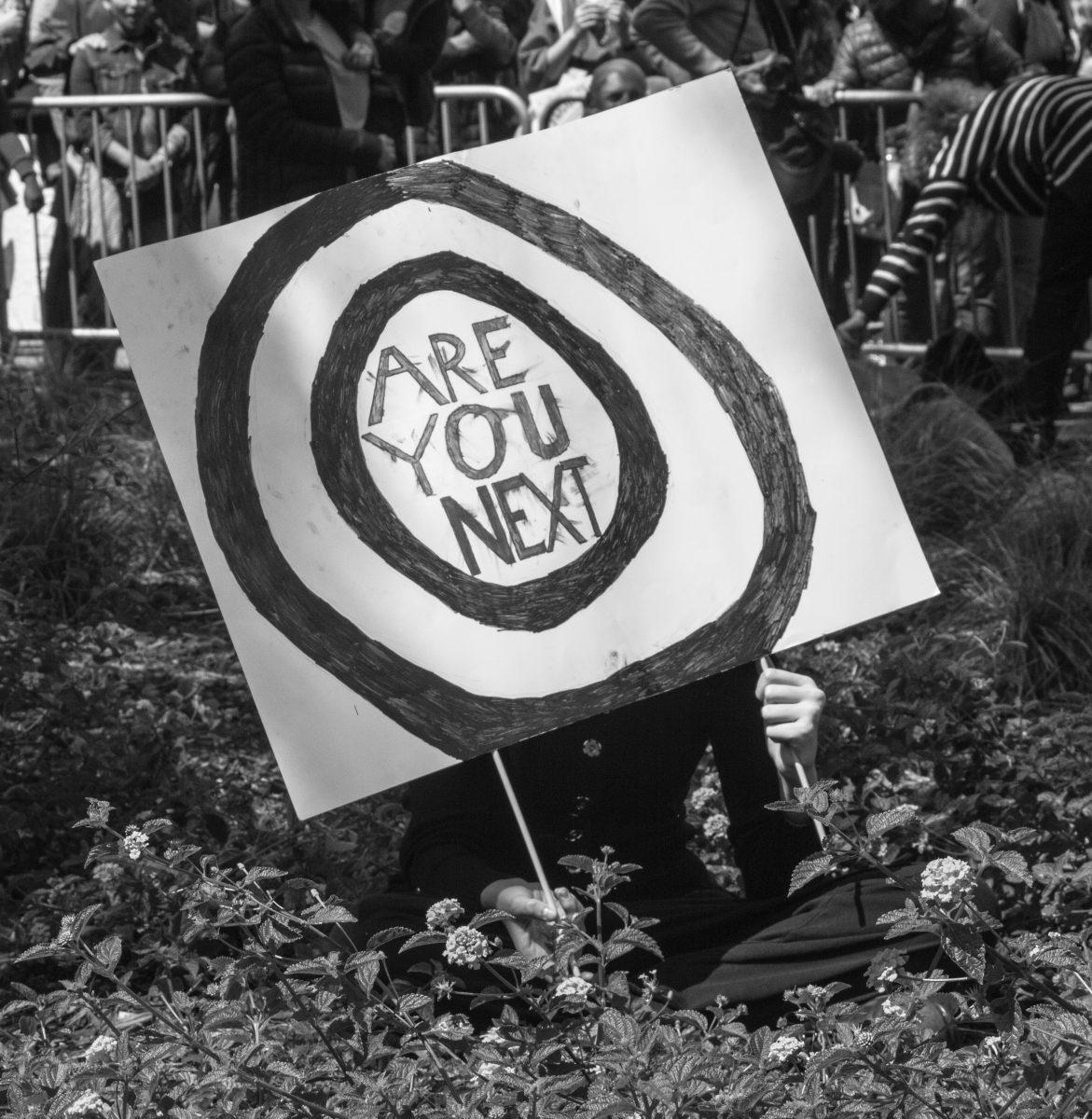 A March For our Lives attendee holds her sign asking "Are you next?" while listening to the speakers. (Elizabeth Tovar Llamas | Viewpoints)