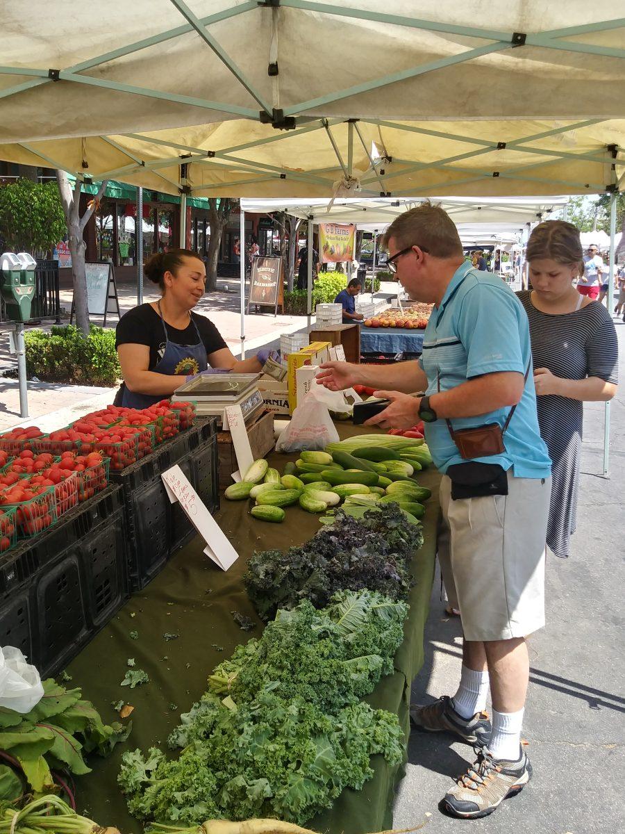 Riverside residents Mike and Victoria Van Hulle purchase local cucumbers from Sandra Buenrostro at Raul and Family Farms on Aug. 17 at the Riverside Downtown Farmers Market. The farmers market brings small business’ fresh produce from the immediate area at affordable rates to the downtown area. Imari Rede | Viewpoints