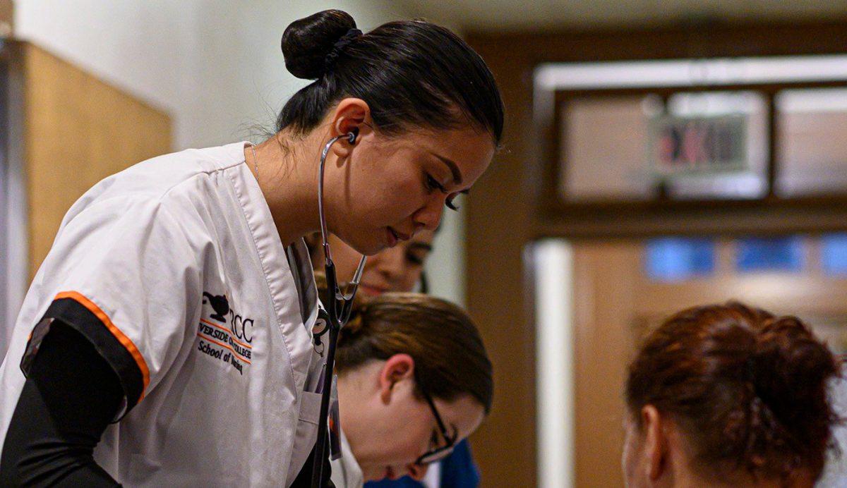 A Riverside City College nursing student tends to a patient at the Riverside Free Health Clinic on March 11. (Angel Peña | Viewpoints)