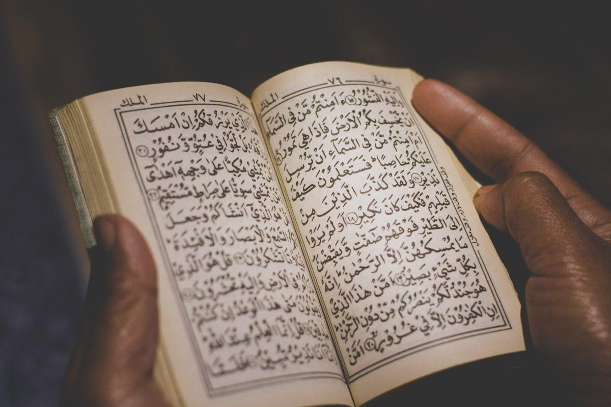 A person holds open the Quran. (Image courtesy of Pixabay)