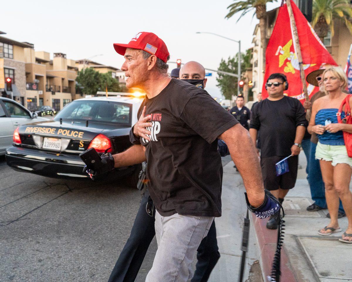 A Riverside police officer holds back a pro-Trump demonstrator after a physical altercation with an unidentified man at the intersection of Third and Market streets in Riverside on Oct. 18. (Photo courtesy of Daniel Hernandez)