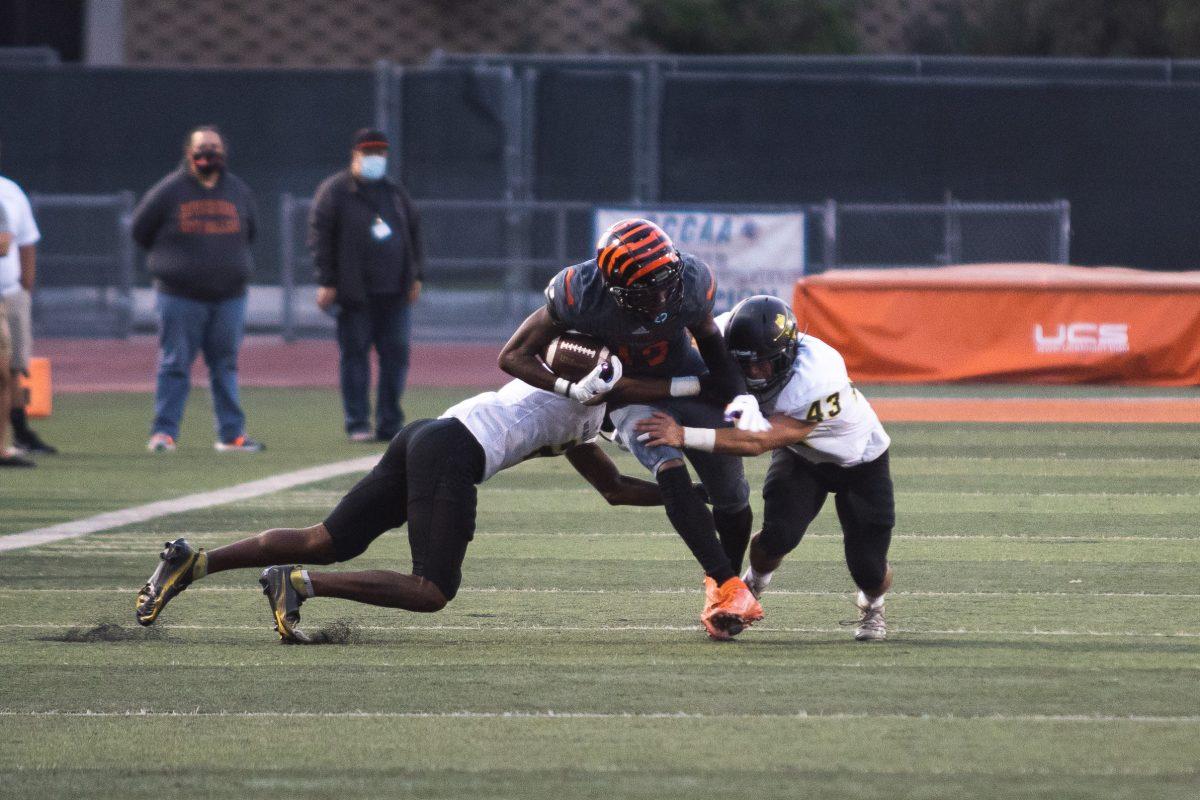 Jammal Houston, RCC wide receiver, completes an 11 yard reception while being tackled by defensive back Dane Despars (43) and Eman Lawoye on Sept. 25. (Daniel Hernandez | Viewpoints)