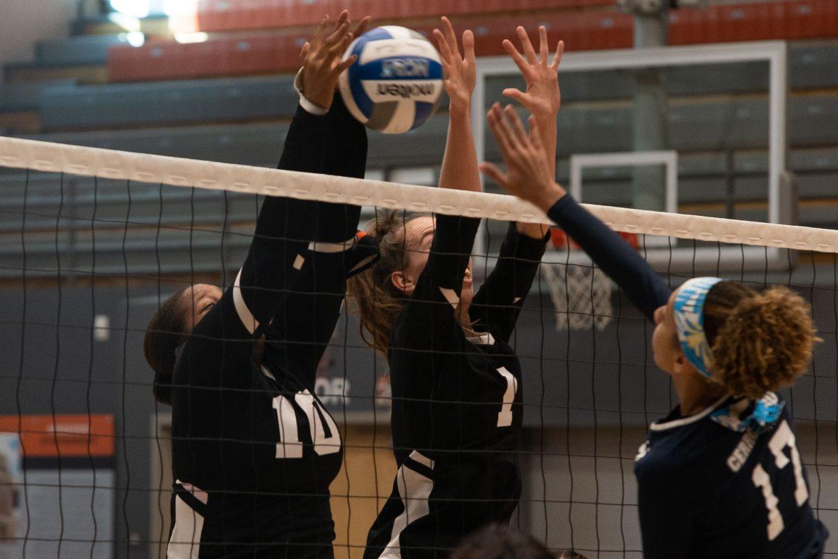 Keeley Hober and Rachel Harris, middle blockers, work together to defend against the opponent's hit on Sept. 9.