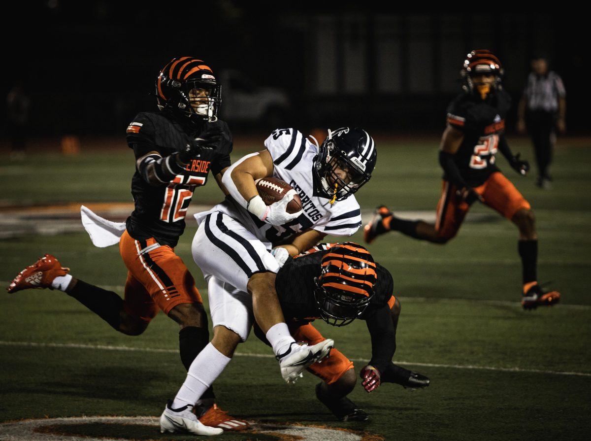 Keith Gooden (20) and Demarco Moorer (12) tackle Penieli Lauago (25) on Nov. 7. (Daniel Hernandez | Viewpoints)