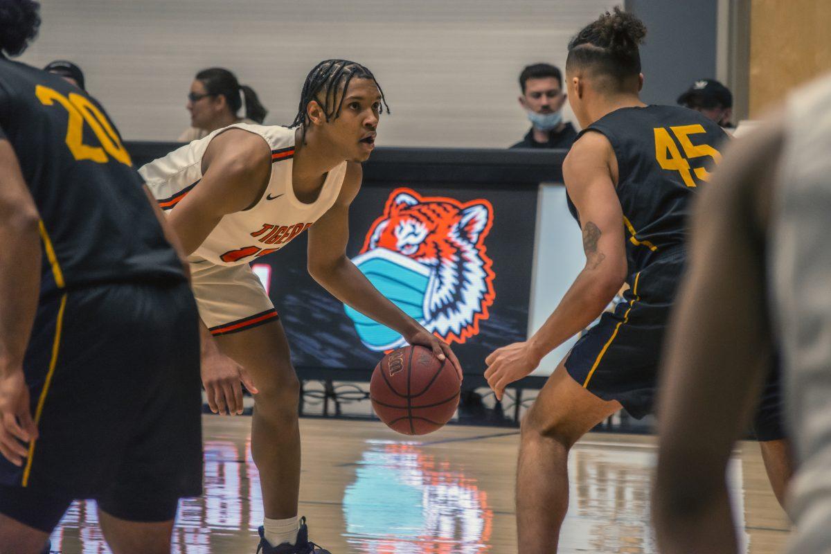 Riverside City College Tiger, Edwyn Collins, 12, eyes the basket as he gets ready to work his way through the Cypress Charger defense Feb 25 at Wheelock Gym. It was the basketball team's final game of the regular season, which they won 92-72. Photo by Stephen Day, Viewpoints.