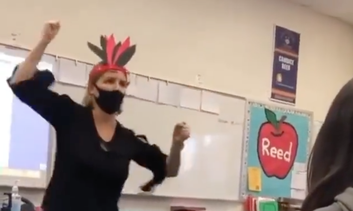 Candice Reed dances in front of students while wearing a fake Native American headdress. (Photo via Twitter)