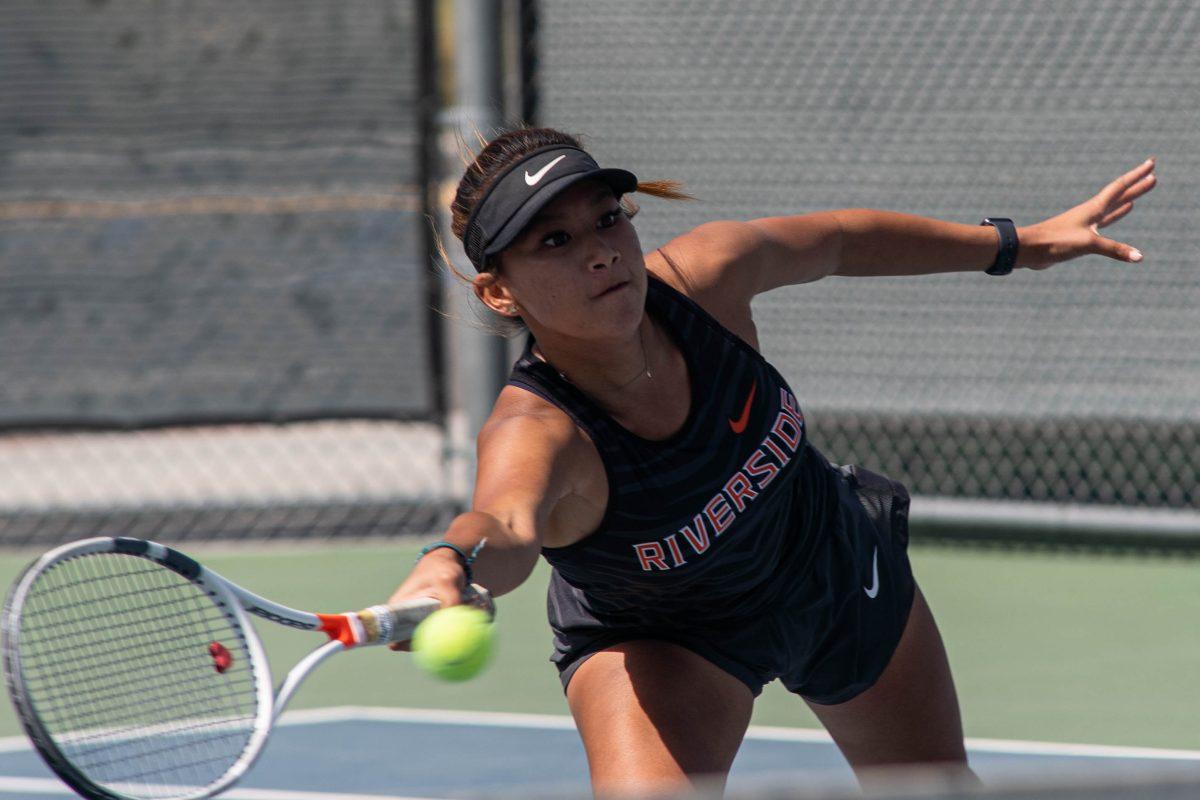 Jillian Stark reaches to hit the tennis ball against Bakersfield College on April 5.