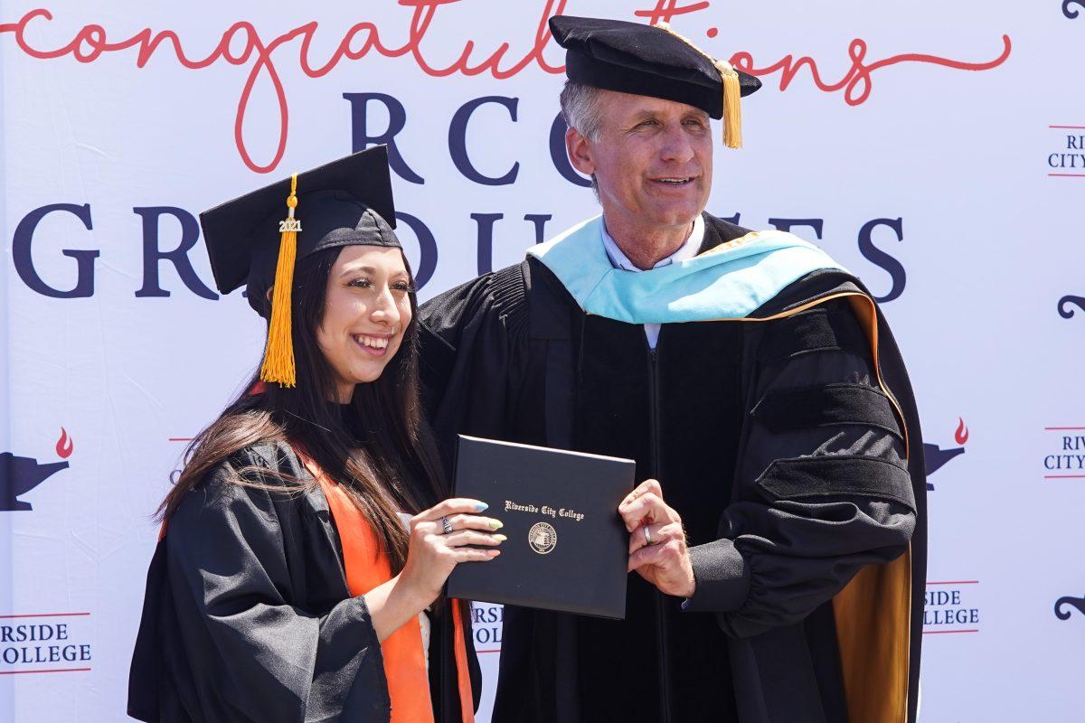 Riverside City College President Gregory Anderson poses with a graduating student at the top of the Parking Structure during the drive-thru commencement ceremony June 2, 2021 (Daniel Hernandez | Viewpoints)
