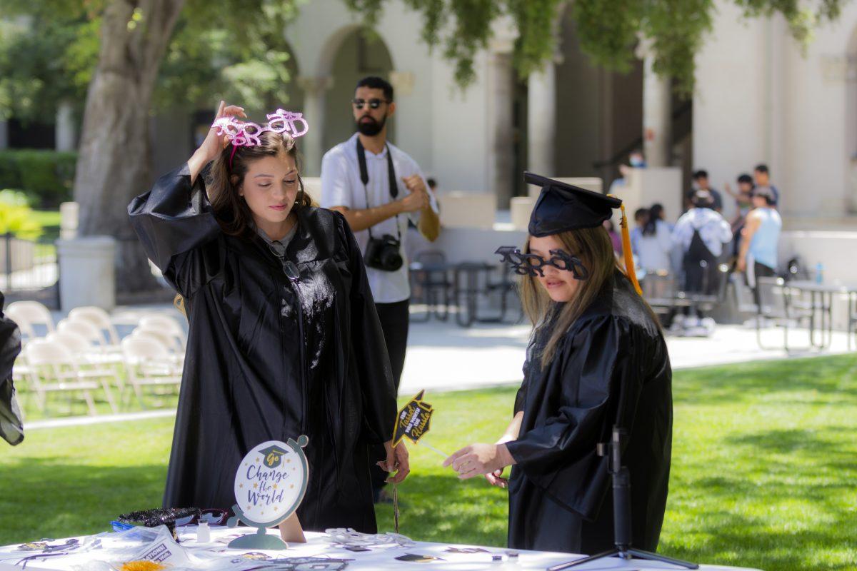 Riverside City College students, Kasandra Caywood (left), and Sandi Bangphraxay, both Math and Science majors, select props to use before having their photo taken at the grad event held in the Quad on May 26. Stephen Day | Viewpoints