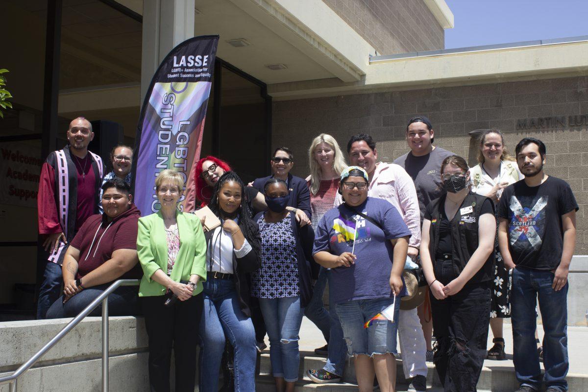 LASSE, SAGA club members, faculty and representatives from various student services pose near the new LASSE flag placed in front of MLK Building on May 19. (Daesha Gear | Viewpoints)