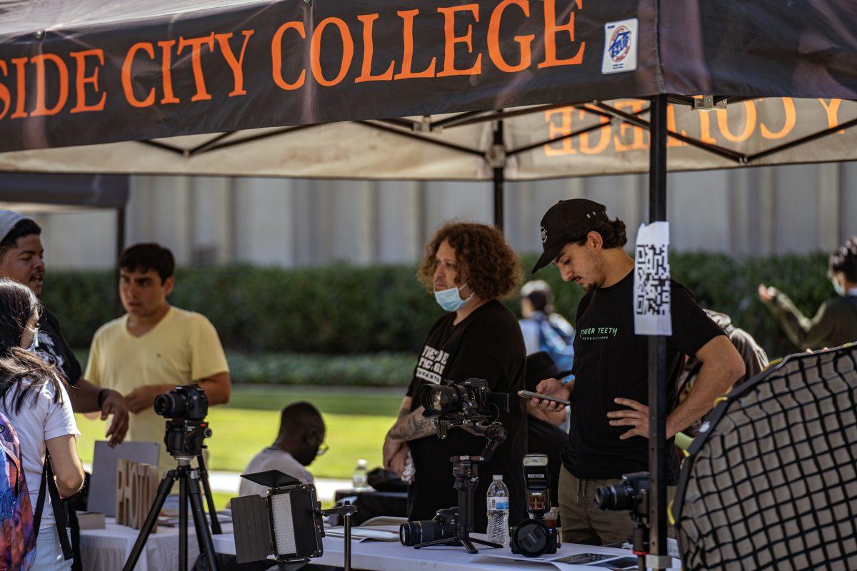 Members of the Photo Club, Juan "Tony" Ramirez, right, Mario Orozco, center, and club president Antonio Vidal, left, showcase a wide variety of photography equipment and photos as they hope to draw the attention of potential club members during Club Rush on Sept 14.

Club Rush is happening Sept 13, 14, and 15 on Terracina Ave.

Photo by Stephen Day, Viewpoints.