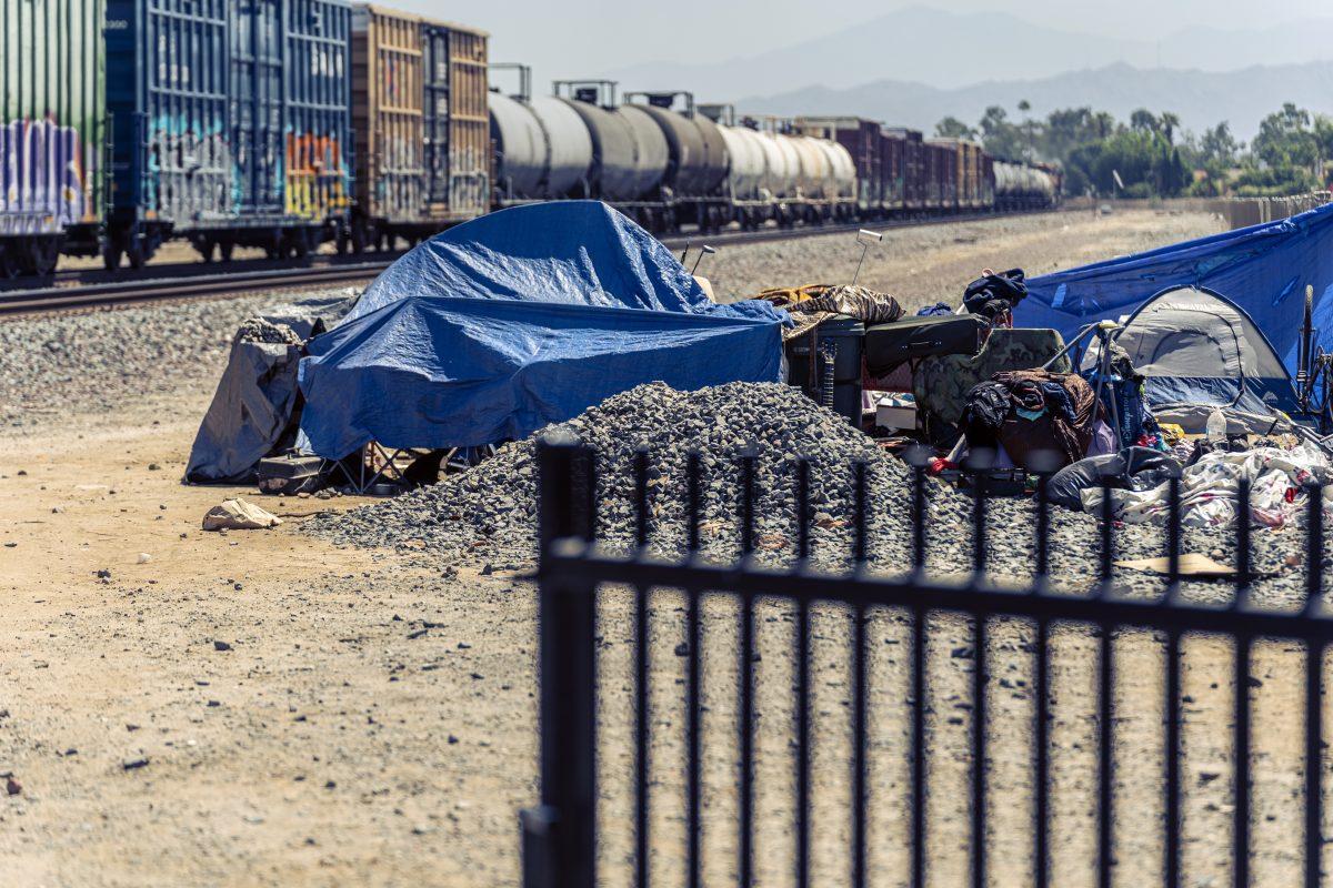 Despite temperatures in the 90's and the danger and noise of passing trains, unhoused Riversidians have set up tent encampents along the train tracks near Tyler and Indiana in Riverside California on Jun 11.  Photo by Stephen Day, Raincross Gazette.