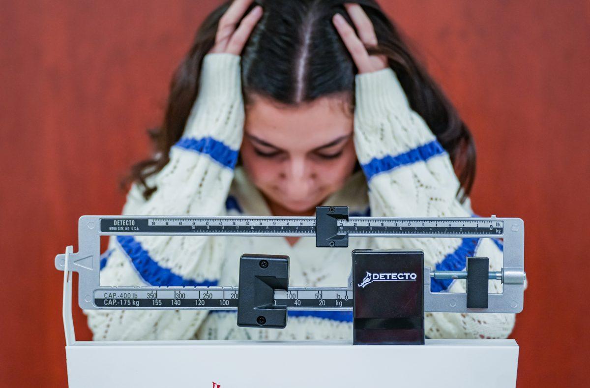 A young healthy woman standing on a scale, feels frustration because she is not seeing the numbers she thinks she needs based on toxic beauty standards.

Photo by Stephen Day, Viewpoints