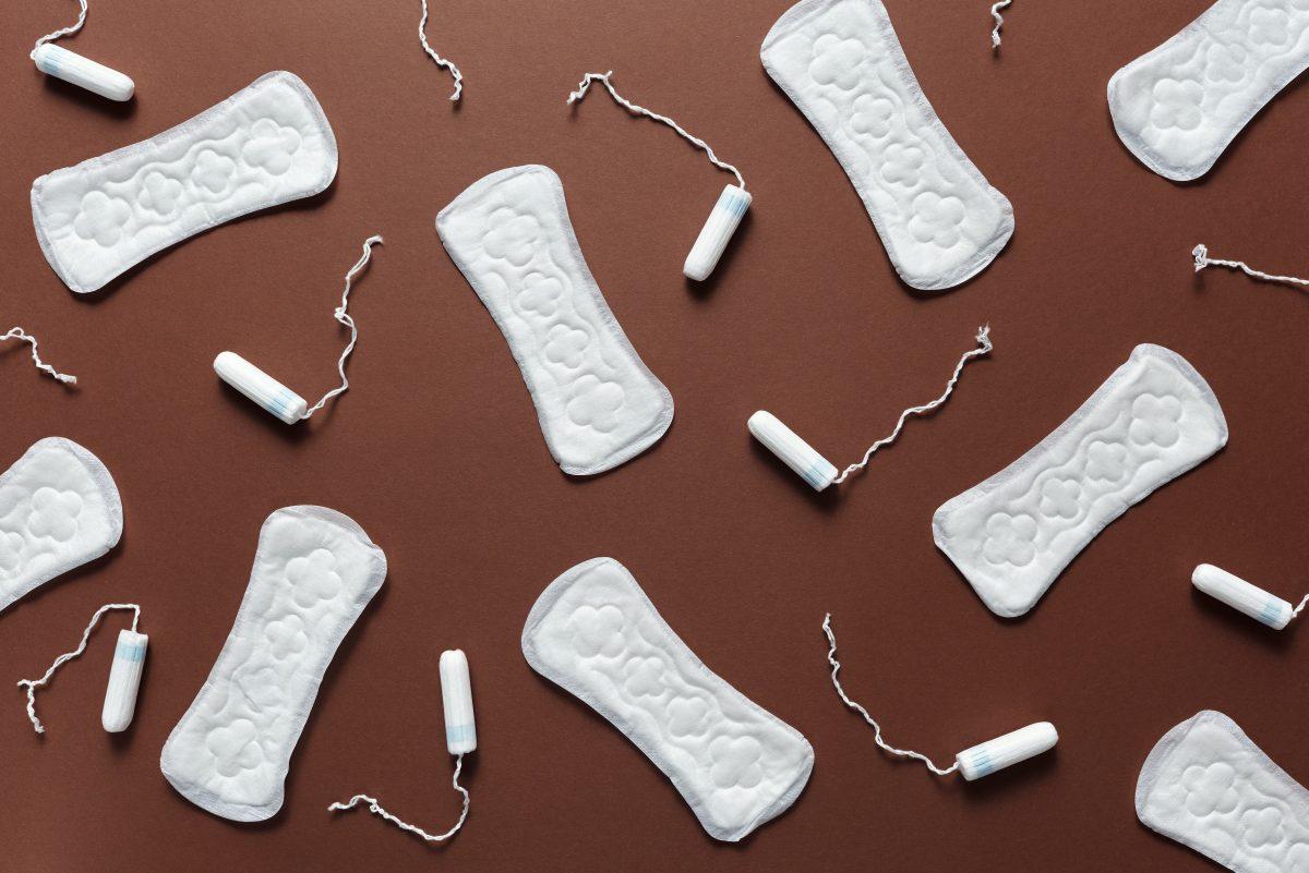 A collection of tampons and pads are laid out on a table.

Photo by Cliff Booth - Pexels.