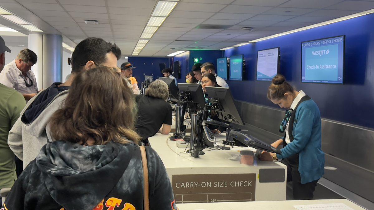 Passengers left at LAX International Airport crowd check-in officers to find new flights to Toronto, Ontario after being left by a Westjet flight pilot Nov. 6. (Photos by John Michael Guerrero)