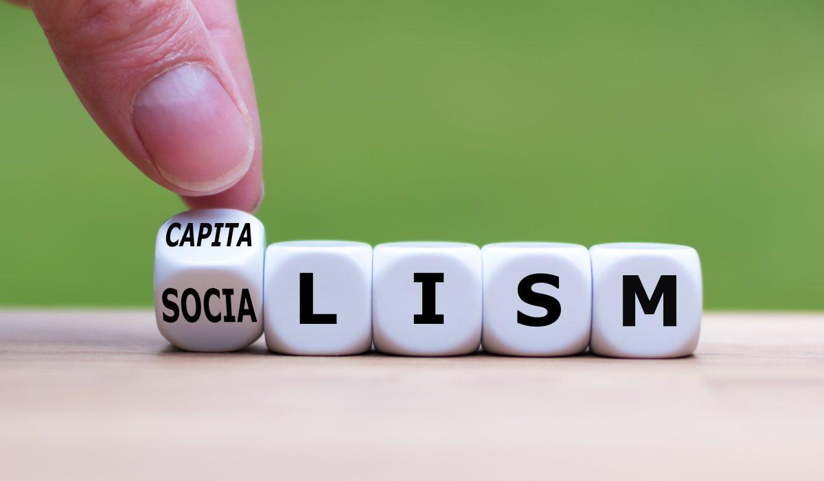 A hand flips a dice and changes the word "Capitalism" to "Socialism".
Photo courtesy of iStock.