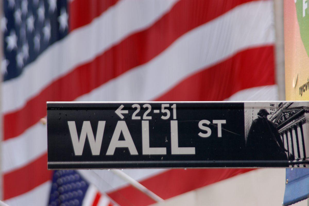 Wall st sign in New York City on Sept 22, 2007, set on the backdrop of the American flag.  Wall Street is widely regarded as the heart of American capitalism.