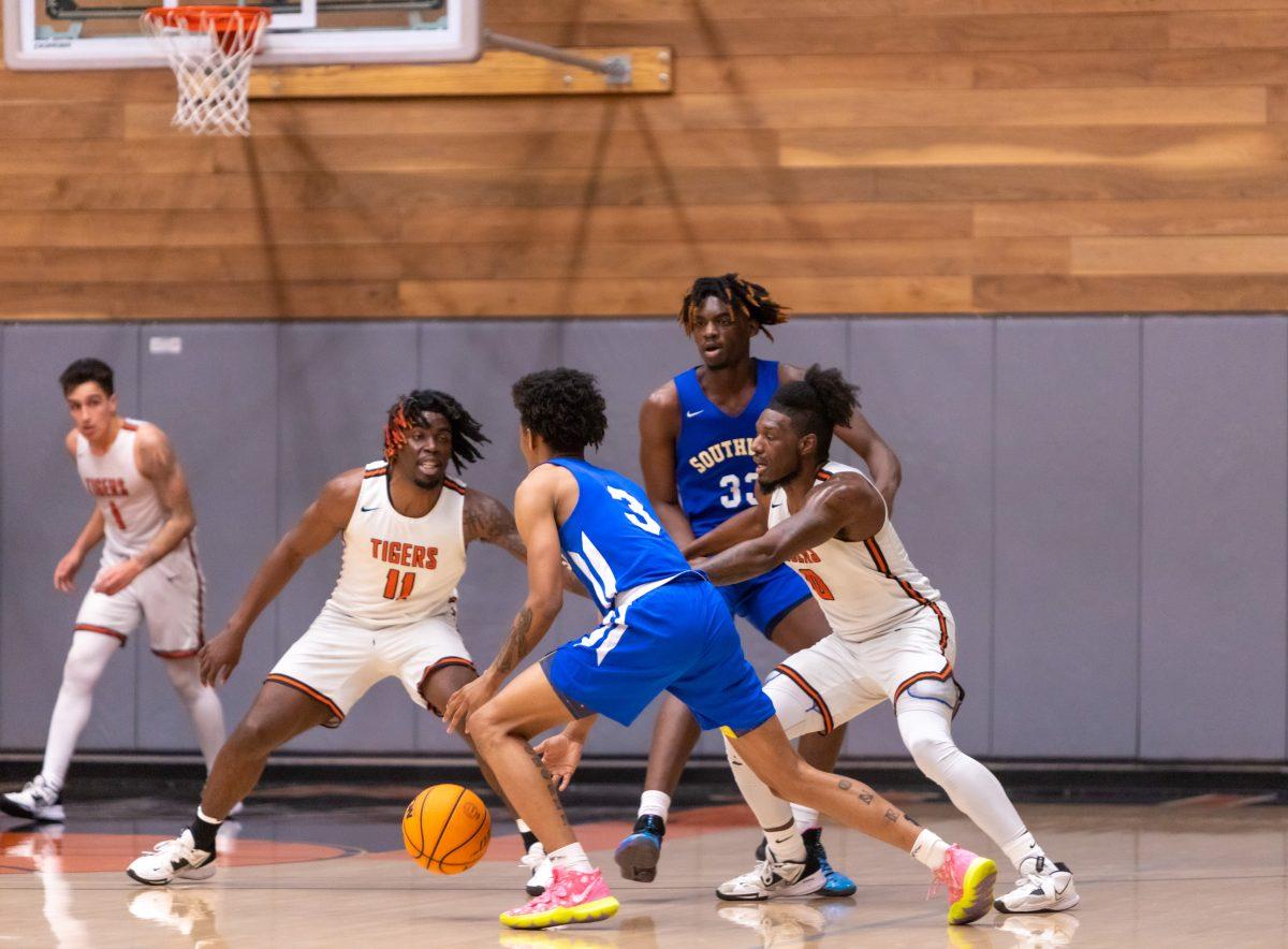 Multiple Tigers swarm a Cougar on defense on Feb. 22 at Wheelock Gymnasium. Photo by Matthew Acosta, Viewpoints.