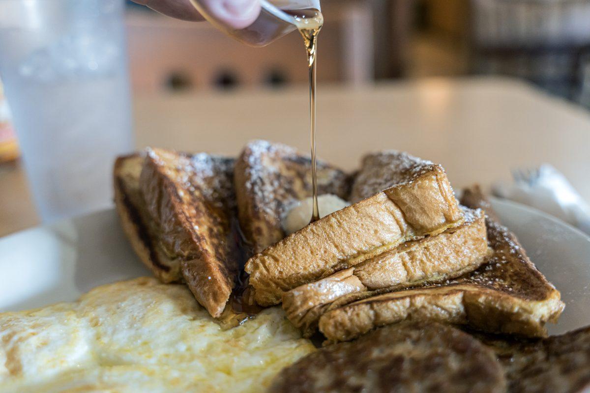 Syrup drizzles over french toast, served with eggs and sausage, as popular menu item at Joanne's Cafe in Riverside on March 22.