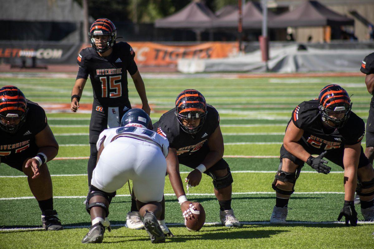 Nephi Kalamafoni-Tuiasosopo, an offensive line player on the Riverside City College Tigers Football team gets ready to snap the ball to Jordan Barton, a Quarterback on the team during their game against the Fullerton Hornets at RCC's Wheelock Stadium on Nov 11. Photo by Adrian Taylor