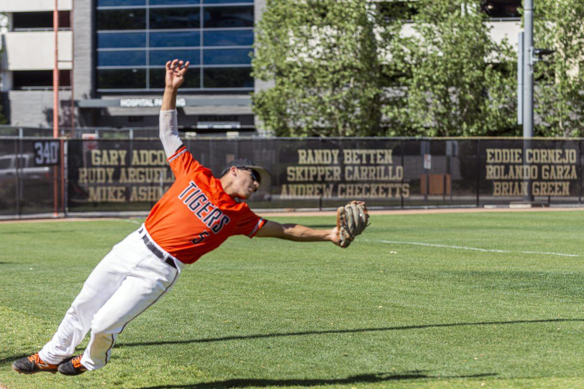 Riverside City Tiger, Ignacio Alvarez, 5, dives back to catch the foul ball. Tigers hosted the Hustlers with a 10-1 victory on April 8. Photo by Stephen Day, Viewpoints.