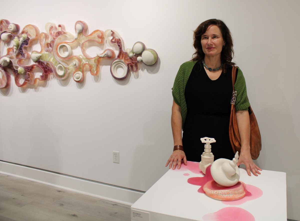 Artist Alison Ragguette stands with her artwork in front of her and behind her at RCC's 2024 Ceramics Invitational on Oct. 3.