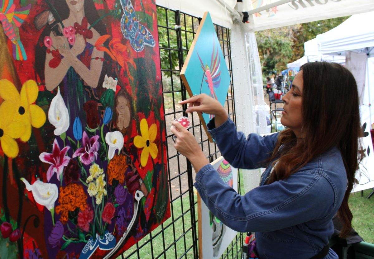 Painter Julia Martinez (featured in article) sets up her booth at Art in the Gardens at University California Riverside.