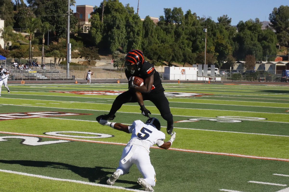 Running Back Andre Branch hurdles a San Diego Mesa defender, #5, to keep the play alive and gain a few more yards on Nov. 9 at Wheelock Stadium.