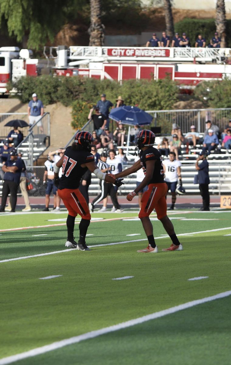 Defensive line, Esaia Bogar, and linebacker, Tayven Anderson, from Riverside City College celebrates successful sack on San Diego Mesa quarterback, Jax Leatherwood, Nov. 30 at Wheelock Stadium.