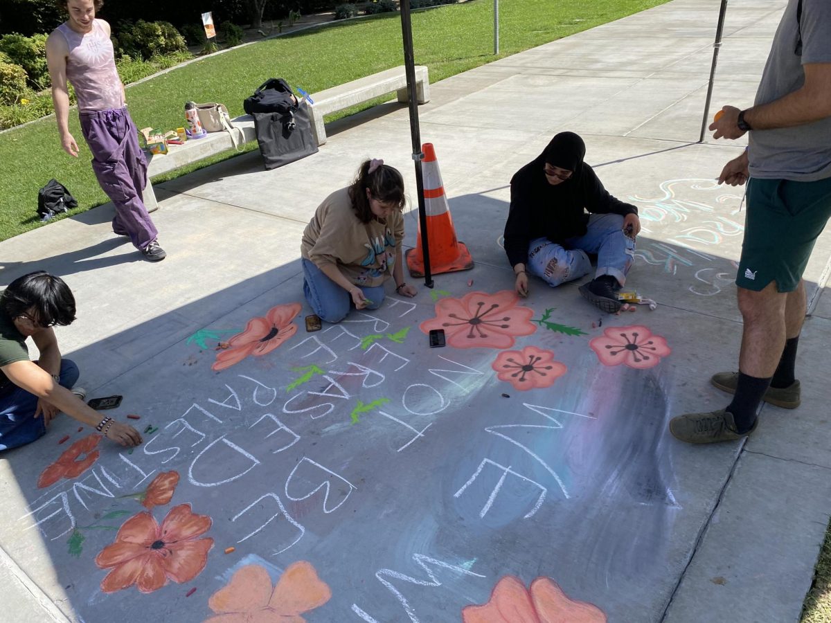 Students for Justice in Palestine work together to create a new art piece during RCC's chalk walk on Oct. 10 in the Quadrangle. 