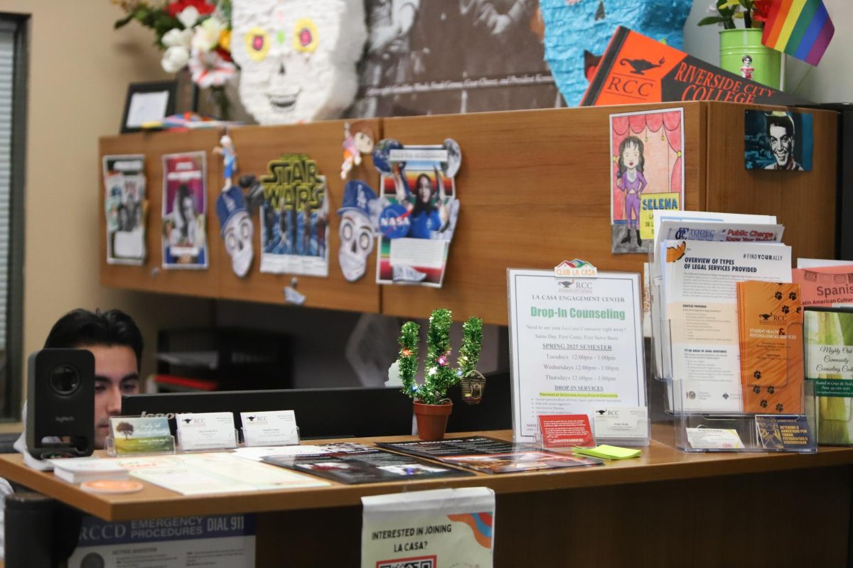 Isreal Sandoval sits at the front desk of La Casa Engagement Center in the Bradshaw Student Center building to provide information and help for students.