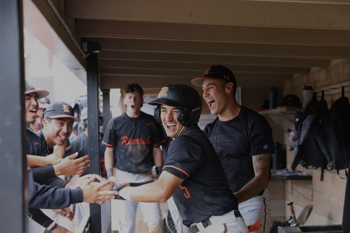 Riverside City College third baseman Eddie Alfaro celebrates with teammates in dug out after scoring a run to take the lead against Antelope Valley College at Evans Sports Complex on May 3.