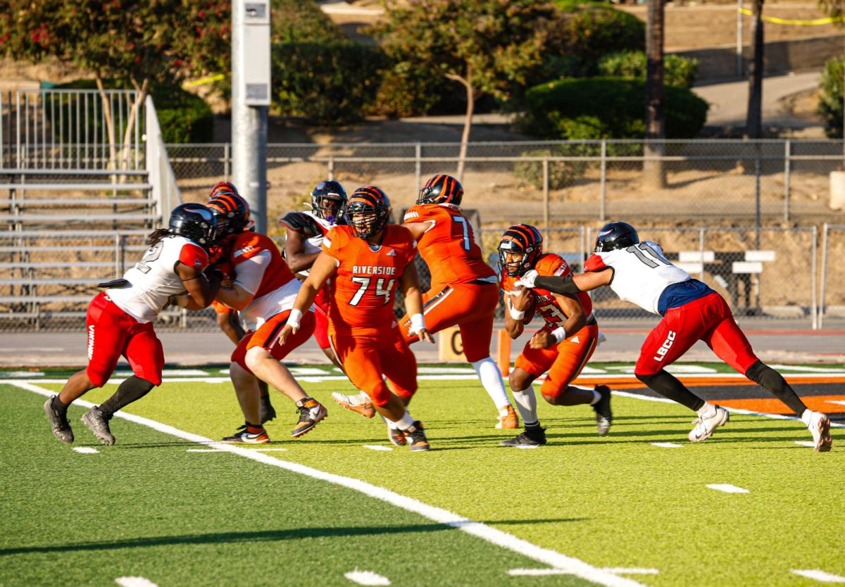 Riverside City College Quarterback #13 Bryan Wilson breaking a tackle against defensive lineman Levar Talley at Wheelock Stadium, Aug. 30.