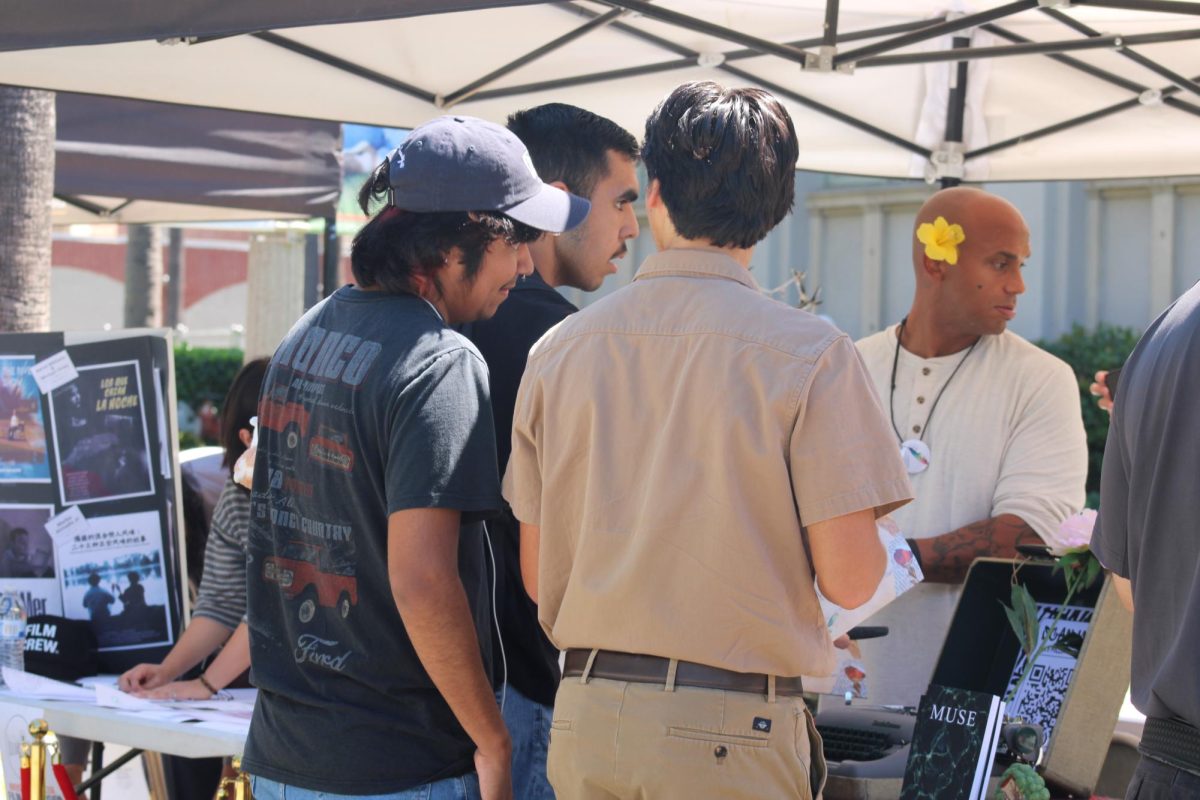 Students learning information about the Muse Club
