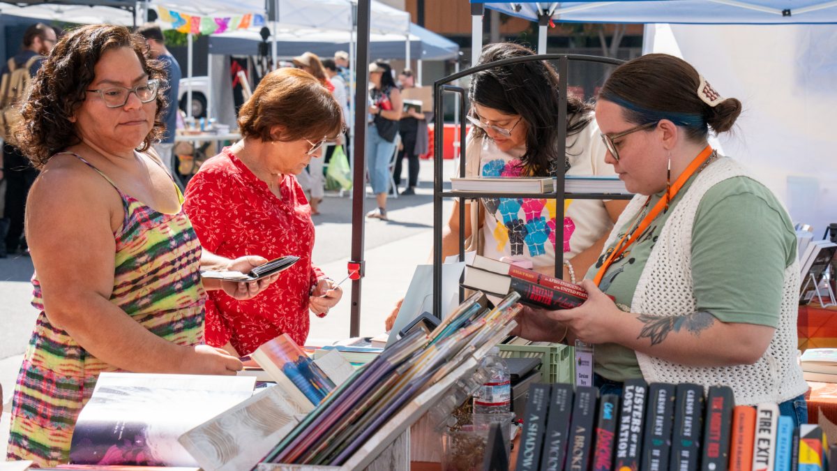 Community members crowd around booth during the Riverside Book Festival on Oct. 11, 2025.