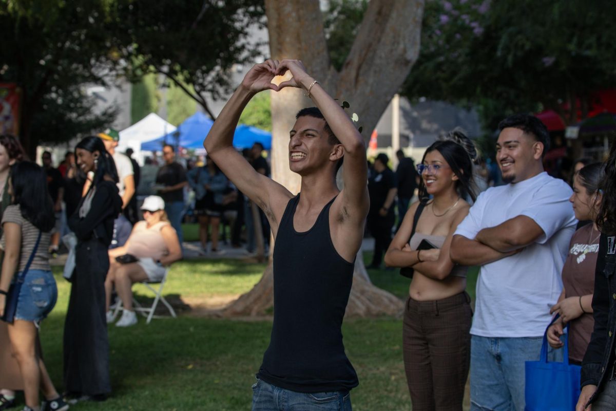 Riverside local, Ricardo Herrera shows love to the band on the stage at the Art and Music Festival at White Park on Sept. 27.